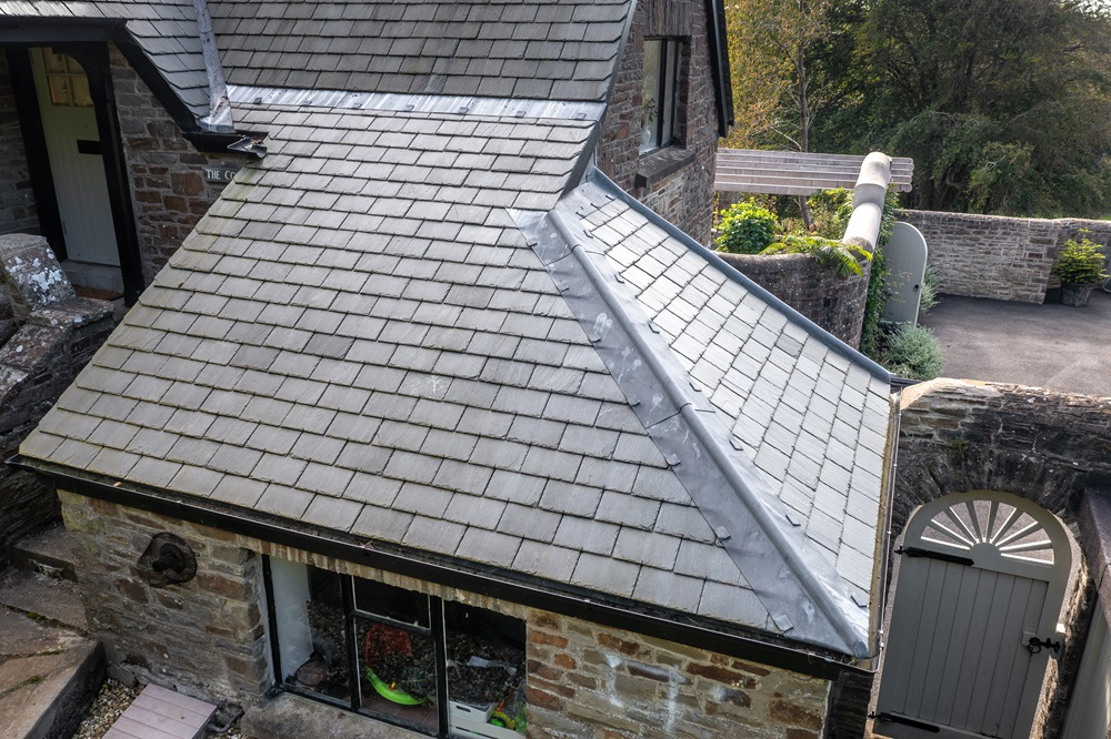 Newly laid natural slate roof with lead hip detailing on a stone cottage
